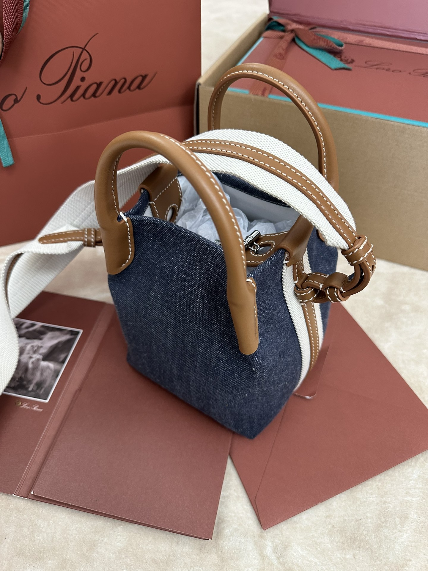 P1280Loro piana Small Bucket Bale Mini Handbag Colour : Blue Denim L'élégance effacée, le goût et le style intemporel du sac Bale témoignent une fois de plus de l'héritage distinctif de Loro pianaLa forme carrée et le nom tiré des grands ballots utilisés pour empiler le cachemire représentent l'adhésion de Loro piana à l'art artisanal de la finesse.Le corps du sac est en cuir de veau et a un aspect naturel très doux. Taille du grain : longueur 16✖️14✖️23CM-sacs haute couture