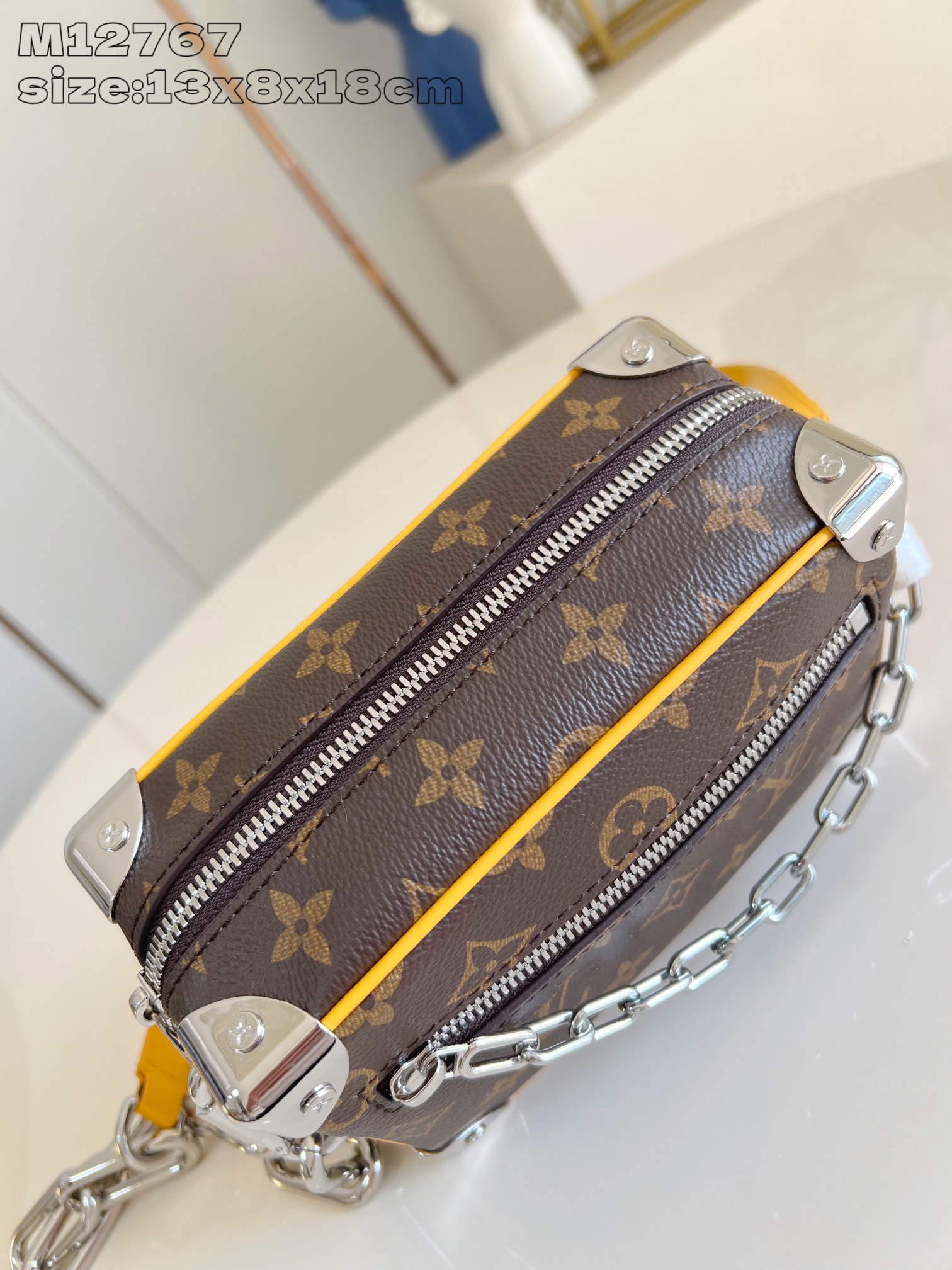 P1100 LV M12767 This Mini Soft Trunk handbag is embellished with metal pieces in Monclerogram Macassar canvas and bright colors for the panels and the edges of the front zipper, striking a balance between creativity and heritage. The striped textile lining and the interior patch pockets create a sophisticated detailing of 13 x 8 x 18.5 cm (H x W x L).