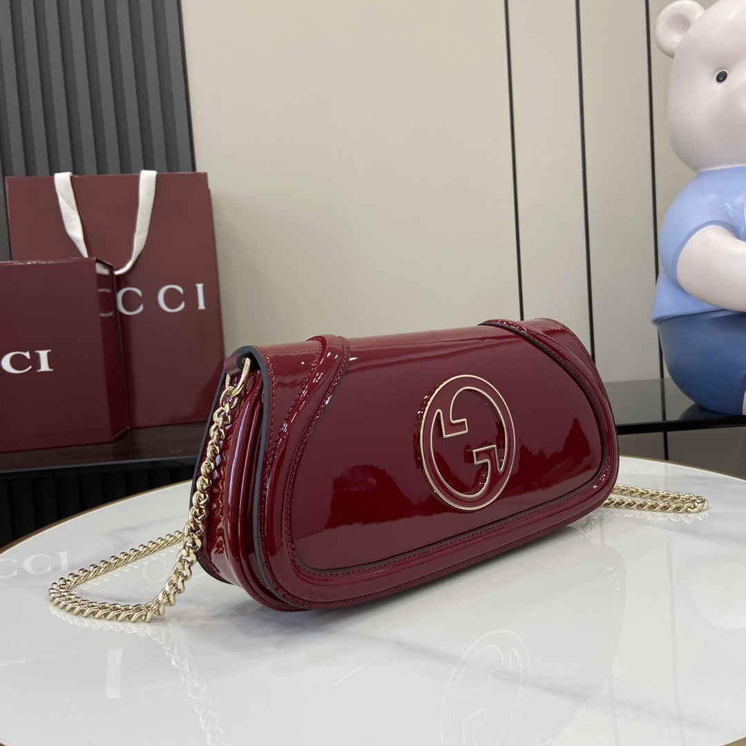 p1400 La nueva colección Gucci Blondie está adornada con el icónico logotipo de la colección, que debutó a principios de la década de 1970, combinando el glamour de la herencia y el estilo contemporáneo para ilustrar el diseño icónico de la marca con un toque moderno. Este bolso bandolera pequeño está confeccionado en charol rojo Anchor de Gucci con el logotipo de la marca esmaltado en forma redonda, y se presenta con una correa para el hombro con cadena en tono dorado.Gucci Encore de charol rojoRibete de charol rojo Gucci EncoreForro en mezcla de algodón y lino marrónDoble G redonda entrelazada esmaltadaInterior: 1 bolsillo con cremalleraExterior: 1 bolsillo de ojal traseroBandolera de cadena desmontable (51 cm de altura)Cierre con broche magnéticoModelo: 814952Dimensiones: 29,5 cm (ancho) x 12,5 cm (alto) x 7 cm (fondo)Peso: aprox. 900 gColor: Rojo Encore charol/Capacidad para iPhone Pro Max/Plus, auriculares Airpods, cartera larga y pintalabiosCreado en Italia