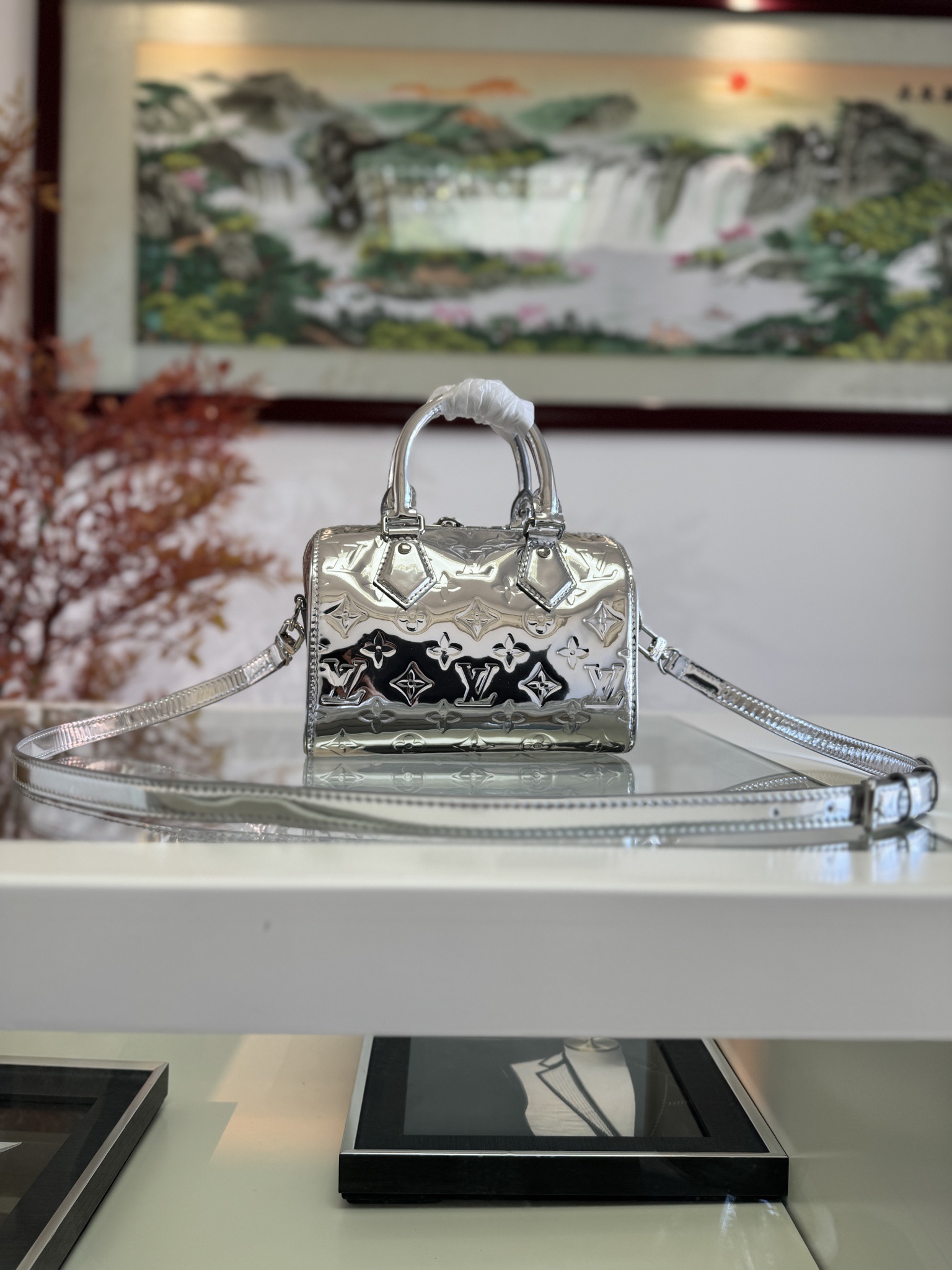 P1360 Lv M11987 BOLSO SPEEDY BANDOULIÈRE 20 charol plateadoEste bolso de mano Speedy Bandoulière 20 de la colección LV Ski está confeccionado en lona revestida gofrada con adornos de piel lisa y piezas de metal brillante y presenta un nuevo efecto Monclerogram Miroir para un look retro-futurista. La correa para el hombro de piel desmontable y ajustable permite una amplia gama de opciones de transporte y es lo suficientemente compacta como para guardar un clip largo para el dinero y otros objetos de uso diario. 12 x 20,5 cm