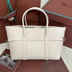 P1840
Loro piana 诺悠翩雅
Ghiera Shopper 小号购物袋 奶油蜂蜜色
采用粒面皮革精制而成超大容量设计Ghiera环扣营造出别致的“腰带”效果使这款手袋既可敞开携带也可闭合携带打造精致的造型皮革手柄可拆卸内袋装饰扣金属色饰面配件羊绒衬里
size：28 x 19 x 12cm
款号FAO7473
配全套专柜礼盒包装🎁-高仿包包