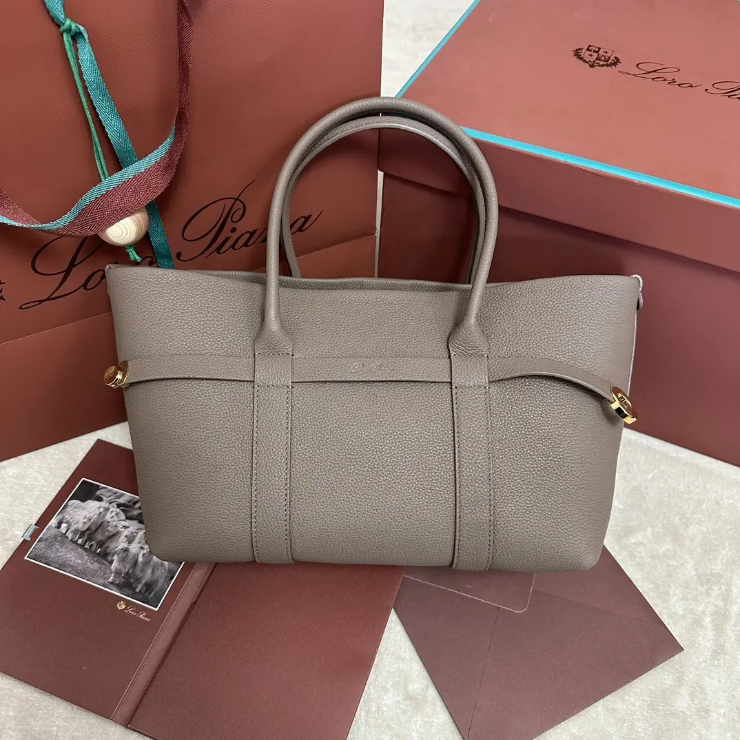 P1840Loro piana Noyo Ghiera Shopper Small Rock Grey Fabriqué en cuir grainé, le passant Ghiera de grande capacité crée un effet 'ceinture' chic, permettant au sac d'être porté ouvert ou fermé pour un look sophistiquéLes poignées en cuir sont détachables. Poches intérieuresBoucle décorativeFinition métalliséeAccessoiresDoublure en cachemireTaille : 28 x 19 x 12cmN° de modèle : FAO7473Livré dans un coffret cadeau 🎁-Sac de haute qualité