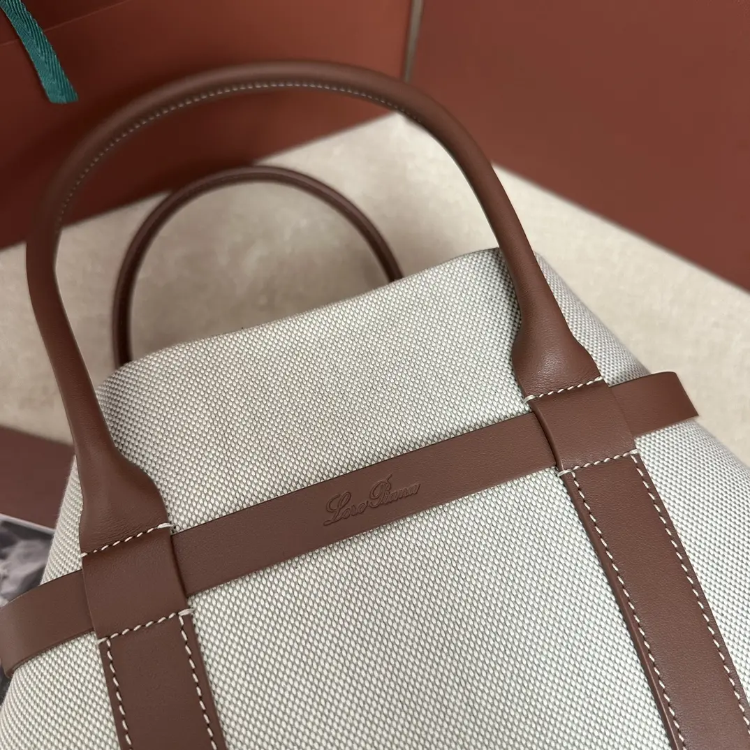 P1740Loro piana Noyo Ghiera Shopper Small Canvas Caramel Confeccionada em pele granulada, o design sobredimensionado do laço da Ghiera cria um efeito de "cinto" chique, permitindo que a mala seja transportada aberta ou fechada para um visual sofisticado Pegas em pele Bolsos interiores amovíveisFivela decorativaAccessóriosAcabamentos em cor metálicaForro em caxemiraTamanho: 28 x 19 x 12cmModelo n.º FAO7473Vem numa caixa de oferta completa 🎁Bolsas de alta qualidade