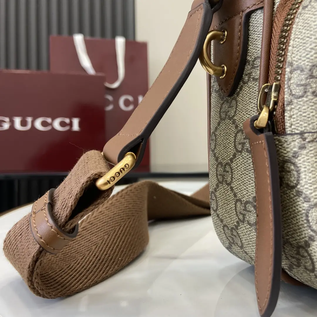 p1080 Gucci Brown Emblem Messenger Bag Les accessoires de voyage pour hommes sont une nouvelle interprétation de l'élégance intemporelle et du savoir-faire de la marqueCe sac à bandoulière est fabriqué dans le nouveau tissu enduit beige et marron foncé monogrammé GGPoche intérieure zippéeAnneau en D extérieur pour les accessoiresNouveau tissu monogrammé GG en beige et marron foncé.Passepoil en cuir marronDoublure en cotonIntérieur : 1 poche zippéeExtérieur : 1 poche zippée et 1 anneau en DBandoulière en toile de 56 cm de haut ; longueur de la bandoulière réglable de 83 cm à 142 cmFermeture à glissièreModèle : 821160Dimensions : 23,5 cm (L) x 18 cm (H) x 8 cm (P)Poids : environ 0,67 gCouleur : pvc marronCréation italienne