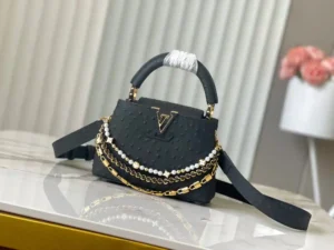 LV Black Ostrich Pearl Trilogy Chain Clause 🔸Esta bolsa Capucines adiciona o clássico couro de vaca Taurillon à coleção Trilogy, dando à elegante corrente uma textura semelhante a uma concha que pode ser usada para iluminar um visual noturno. O compartimento interno inclui um bolso para cartões que pode ser usado no corpo ou como uma bolsa de mão.