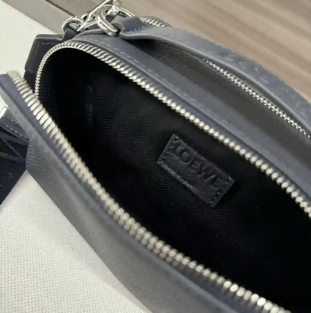 Imagen [8]-P1240 Loewe Mini bolso cruzado multifunción para cámara Funcional y práctico con dos compartimentos con cremallera Esta versión está confeccionada en suave piel de vacuno granulada Puede llevarse cruzado o con el asa superior *Correa de cincha ajustable y desmontable L⊚℮w℮ *Bolsillos interiores *Forro de lona de algodón con estampado de espiga*. Anagrama en relieveTamaño: 18*7*13cmModelo: 062399-Bolso de alta costura