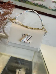 LV x TM TWIST SLIM Medium Handbag M13243 D'un blanc pur, ce Twist Slim Medium Handbag M13678 présente une texture chic en cuir de vachette grainé Epi, qui se transforme ensuite en une silhouette moderne avec la serrure Twist Twist iconique de LV et les anses Toron en métal éblouissant ornées d'un motif Monclerogram coloré de la collection réimprimée Louis Vuitton x Takashi Murakami Dimensions : 23,0 x 16,0 x 8,0 cm : 23,0 x 16,0 x 8,0 cm-High Fake Bags