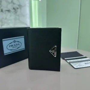 PRADA Short Wallet 1ML050 Ce portefeuille en cuir Saffiano est orné d'un logo triangulaire en métal émaillé dans un design épuré et élégantPortefeuille aux lignes simplesComprend un compartiment à monnaie zippé, un compartiment à billets et des fentes pour cartesLe modèle est conçu avec six fentes pour cartes à l'intérieur, deux poches intérieures et un compartiment à billets pour garder les effets personnels en sécuritéC'est une pièce de collectionDimensions:11.5*8.5cm-Sacs à main de haute qualité