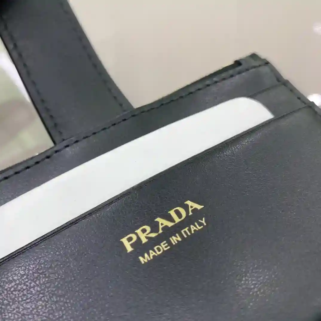 Imagen [9]-PRADA Tarjetero para mujer 1MC038164 Código OEM Este exquisito tarjetero combina piel lisa y detalles en piel saffiano La piel saffiano con textura de pespuntes cruzados es el material característico de Prada Diseñado para la simplicidad y la atmósfera con un logotipo triangular esmaltado embellecido para mostrar los elementos icónicos También viene con bolsillos con cremallera con cinco ranuras para tarjetas Dimensiones: largo 12cm alto Bolsos falsos de 7,5 cm de alto