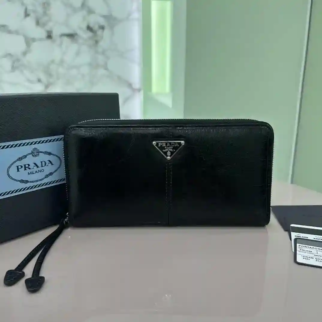 PRADA Single Zip Wallet 2ML059 Inside Code 164 OEM Ce portefeuille pratique est fabriqué en cuir brillant avec un grand espace intérieur soulignant des lignes lisses et des motifs géométriques classiques mettant en valeur l'élégance sophistiquée du style moderne A l'intérieur, il y a 6 fentes pour cartes 2 compartiments pour billets 2 poches pour documents Taille : 20cm*10.3cm-Sacs à main de haute qualité