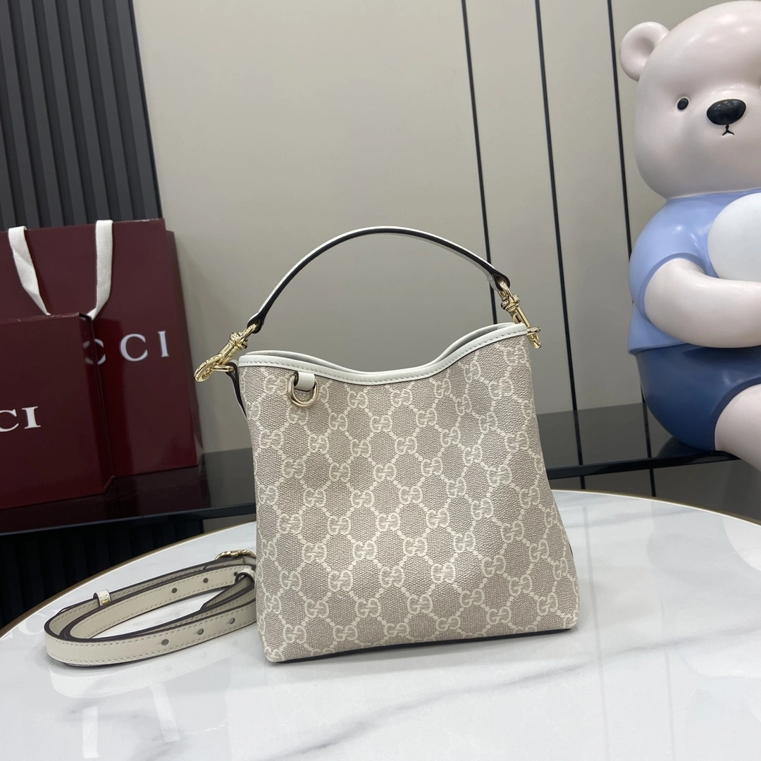 p920 Gucci Emblem系列焕新诠释品牌的隽永优雅风范和精湛工艺这款迷你水桶包设有一个内部隔层时尚而不失实用性米色和白色全新GG字母图案涂层织物米白色皮革滚边饰对比色缝线钩扣开合手柄；高14厘米另配有用于系挂可拆卸物品的D形环内部：2个隔层和1个中央按扣隔层可拆卸可调节皮革肩带（高52厘米 – 57.5厘米）；长度可在107厘米与114厘米之间调节磁力按扣开合型号：815118尺寸：19厘米（宽）x 18厘米（高）x 11厘米（深）颜色：米胶米白皮/重量：约0.45千克意大利创作-高仿包包