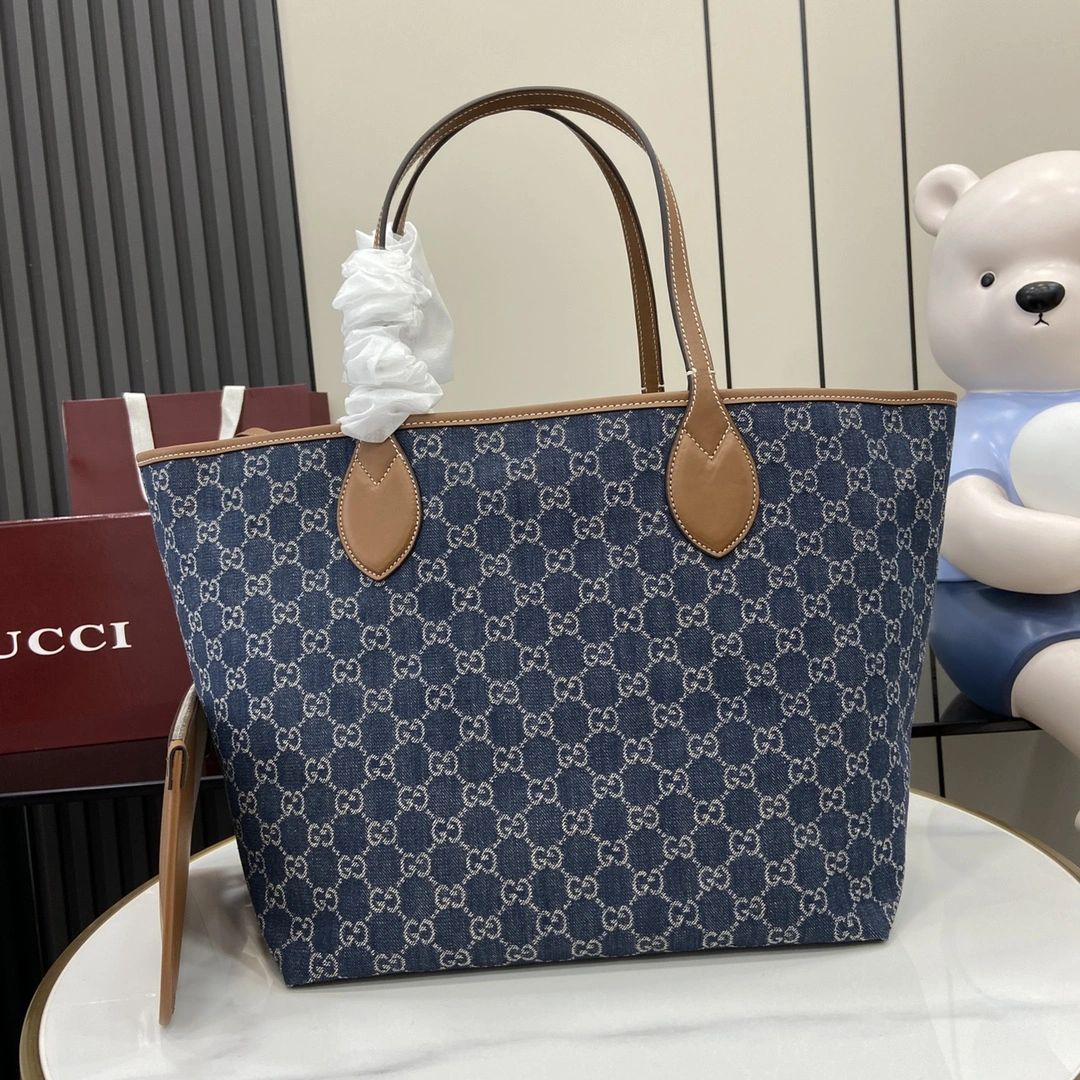 p1120 Gucci Totissima系列糅合“tote”一词与意大利语中表示最高级的词语“issima”彰显这款手袋的实用功能和隽永底色这款中号托特包内附可拆卸手拿包
蓝色GG牛仔面料
棕色皮革滚边饰对比色缝线
蓝色棉麻衬里
可拆卸手拿包：21.5厘米（宽）x 12.5厘米（高）
顶部提手（21厘米高）
型号：820481
尺寸：30.5厘米（宽）x 28厘米（高）x 27厘米（深）
颜色：蓝色牛仔面料/
重量：约0.6千克
意大利创作-高仿包包