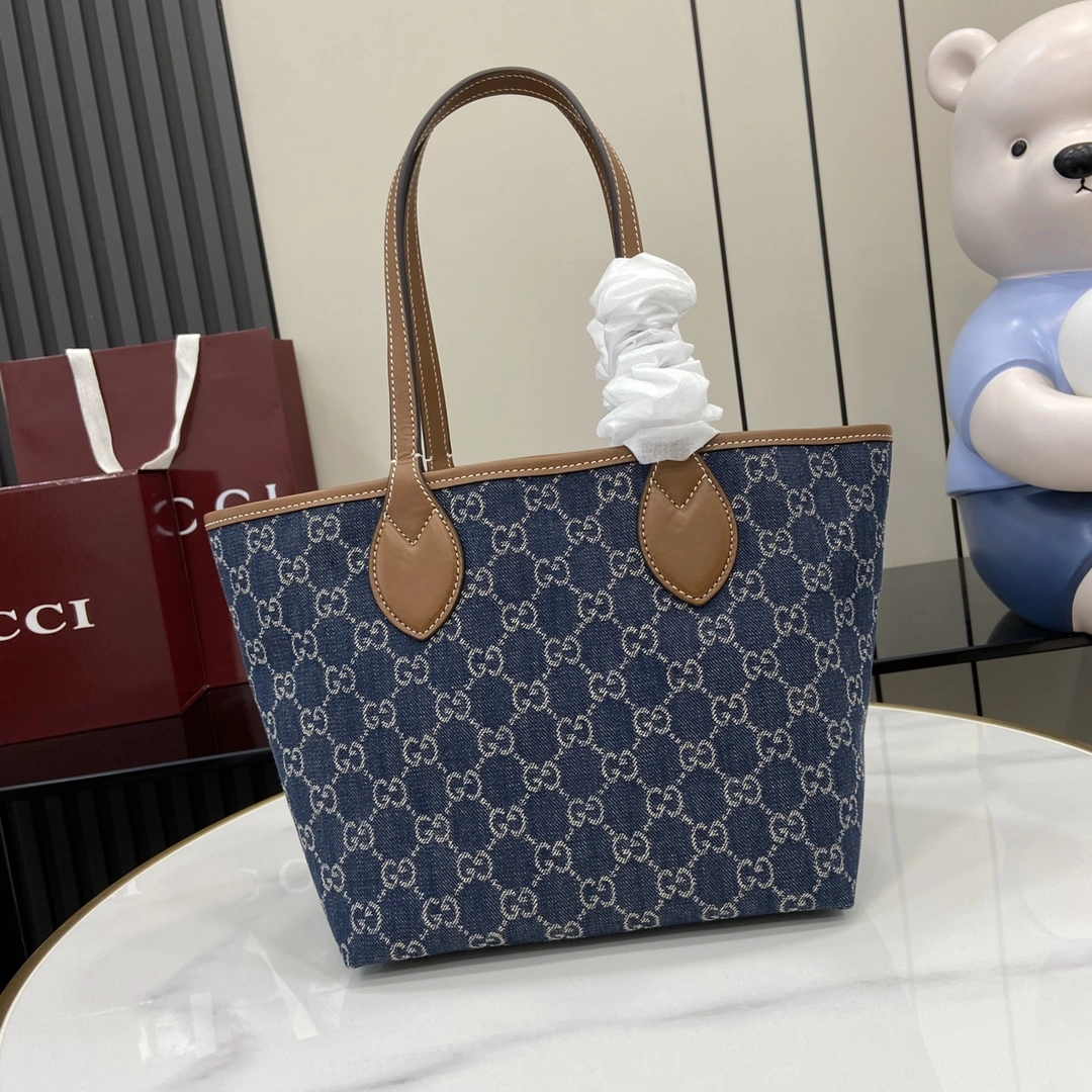 p980 A coleção Gucci Totissima combina a palavra "tote" com a palavra italiana para a classe mais elevada, "issima", para realçar a praticidade e a intemporalidade deste pequeno sacoBase: azulGanga Ganga castanha Tubo em pele com pesponto contrastanteForro em linho de algodão azulAlças superiores (20cm de altura)Modelo: 820496Tamanho: 22cm (C) x 19cm (L) x 18cm (P)Cor: AzulGangaDenimPeso: Aprox. 0,3kgCriação Italiana - Malas de gama alta