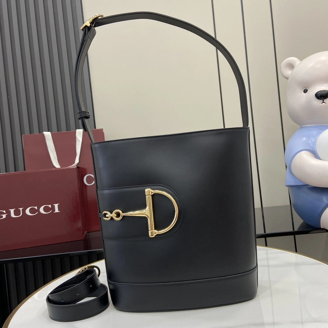 p1380 Para la colección Primavera/Verano 2025, Gucci 73 se inspira en un bolso bucket de coleccionista lanzado el mismo año que su homónimo Este bolso es una interpretación estética moderna del accesorio en forma de bocado Puede llevarse cruzado, colgado del hombro o como bolso tote Piel negra brillante Tono dorado Accesorio en forma de medio bocado de gran tamaño Forro en mezcla de algodón y lino marrón Interior: 1 bolsillo con cremallera Correa para el hombro (27 cm de alto); Viene con una bolsa desmontable (50 cm de alto) Cierre magnético a presión Modelo: 833660 Tamaño: 26 cm (ancho) x 27,5 cm (alto) x 11,5 cm (profundidad) Color: Grama Piel plena/ Peso: Aprox. 0,8 kg Italian Creations - Bolsos de alta calidad