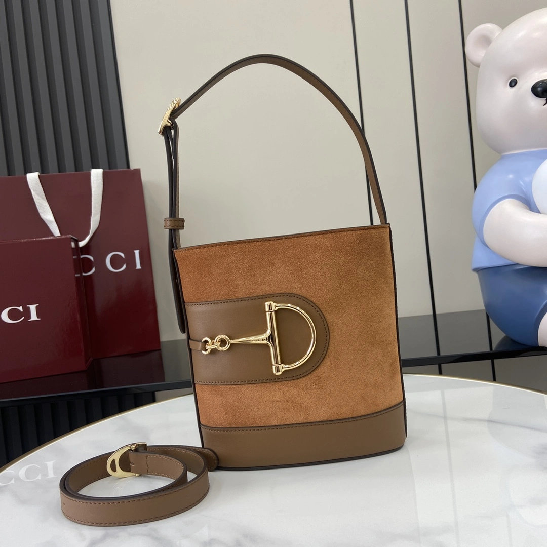 p1060 En la colección Primavera/Verano 2025 Gucci 73 se inspira en el bolso bucket de archivo de la cosecha homónima Está diseñado con herrajes contemporáneos de hebilla de herradura Puede llevarse cruzado, al hombro o como bolso tote Piel de vacuno cepillada marrón Ribete de piel marrón Tono dorado Grandes medias espuelas Herrajes Forro de lino de algodón marrón Interior: 1 bolsillo con cremallera Correa para el hombro (19 cm de altura) Correa desmontable adjunta (50 cm de altura) Cierre magnético CierreModelo: 833665Tamaño: 18,5 cm (ancho) x 20 cm (alto) x 8,5 cm (fondo)Peso: aprox. 0,5 kgColor: Marrón esmerilado/Creación italiana - Bolsos de alta calidad