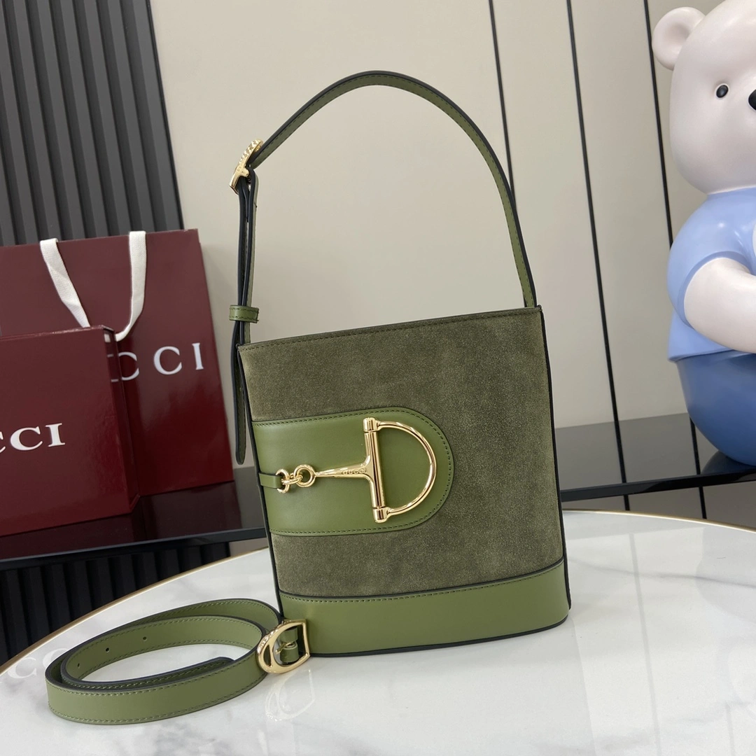 p1060 En la colección Primavera/Verano 2025 Gucci 73 se inspira en el bolso bucket de archivo de la colección homónima Está diseñado con herrajes contemporáneos de hebilla de herradura Puede llevarse cruzado, al hombro o como bolso tote Piel de vacuno cepillada verde Ribetes de piel marrón Tono dorado Herrajes de media espuela grandes Forro de lino de algodón marrón Interior: 1 bolsillo con cremallera Correa para el hombro (19 cm de altura) Correa desmontable adjunta (50 cm de altura) Cierre magnético CierreModelo: 833665Tamaño: 18,5 cm (ancho) x 20 cm (alto) x 8,5 cm (fondo)Peso: aprox. 0,5 kgColor: Verde esmerilado/Creaciones italianas - Bolsos de alta calidad