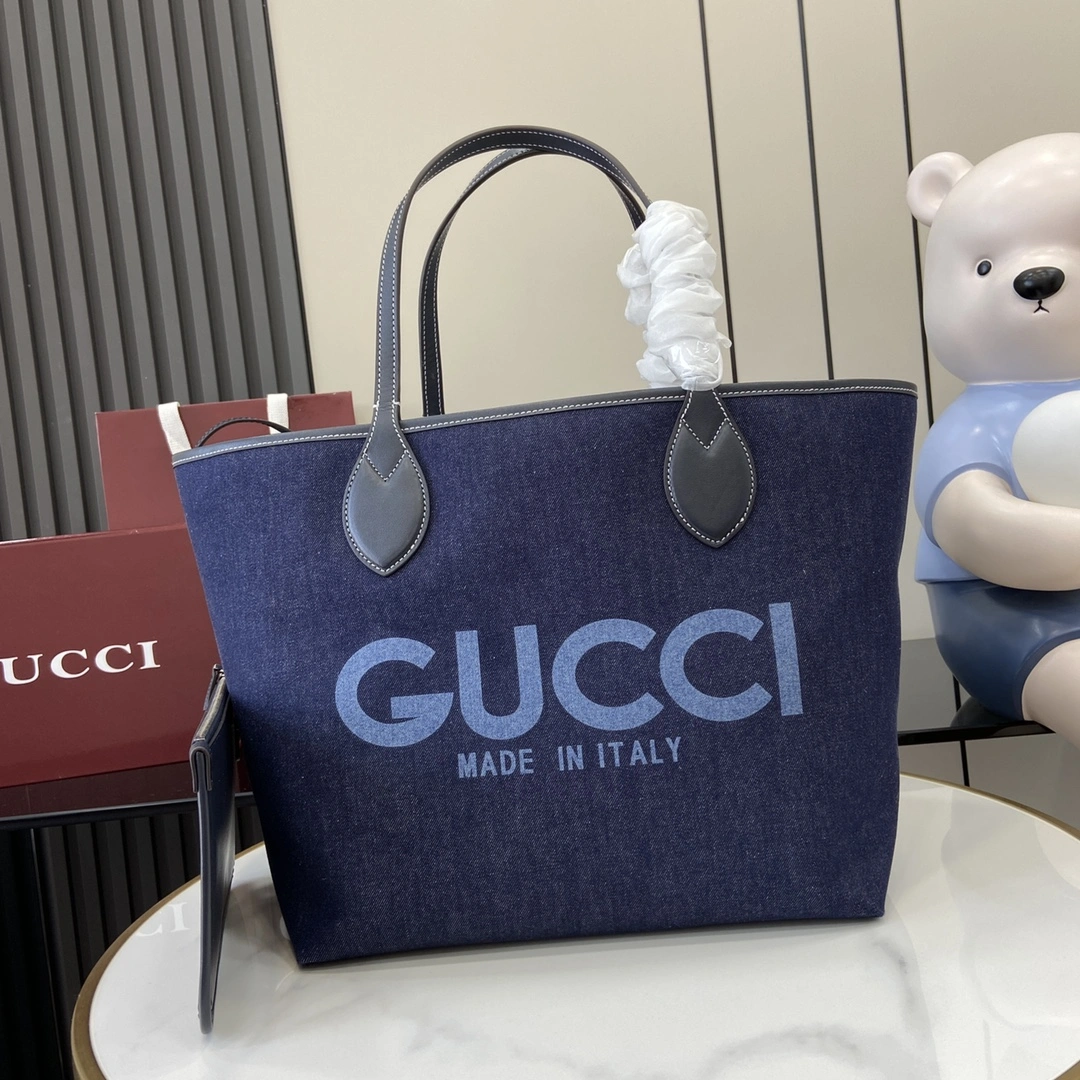 p1120 Gucci Totissima系列糅合“tote”一词与意大利语中表示最高级的词语“issima”彰显这款手袋的实用功能和隽永底色这款中号托特包采用双面设计内附可拆卸手拿包
一面是深蓝色牛仔布另一面是米色和蓝色GG Supreme帆布
饰撞色缝线深蓝色皮革滚边
“Gucci Made in Italy”印花
可拆卸手拿包：21.5厘米（宽）x 12.5厘米（高）
顶部提手（21厘米高）
型号：820481
尺寸：30.5厘米（宽）x 28厘米（高）x 27厘米（深）
重量：约0.6千克
颜色：深蓝牛仔布/
意大利创作-高仿包包